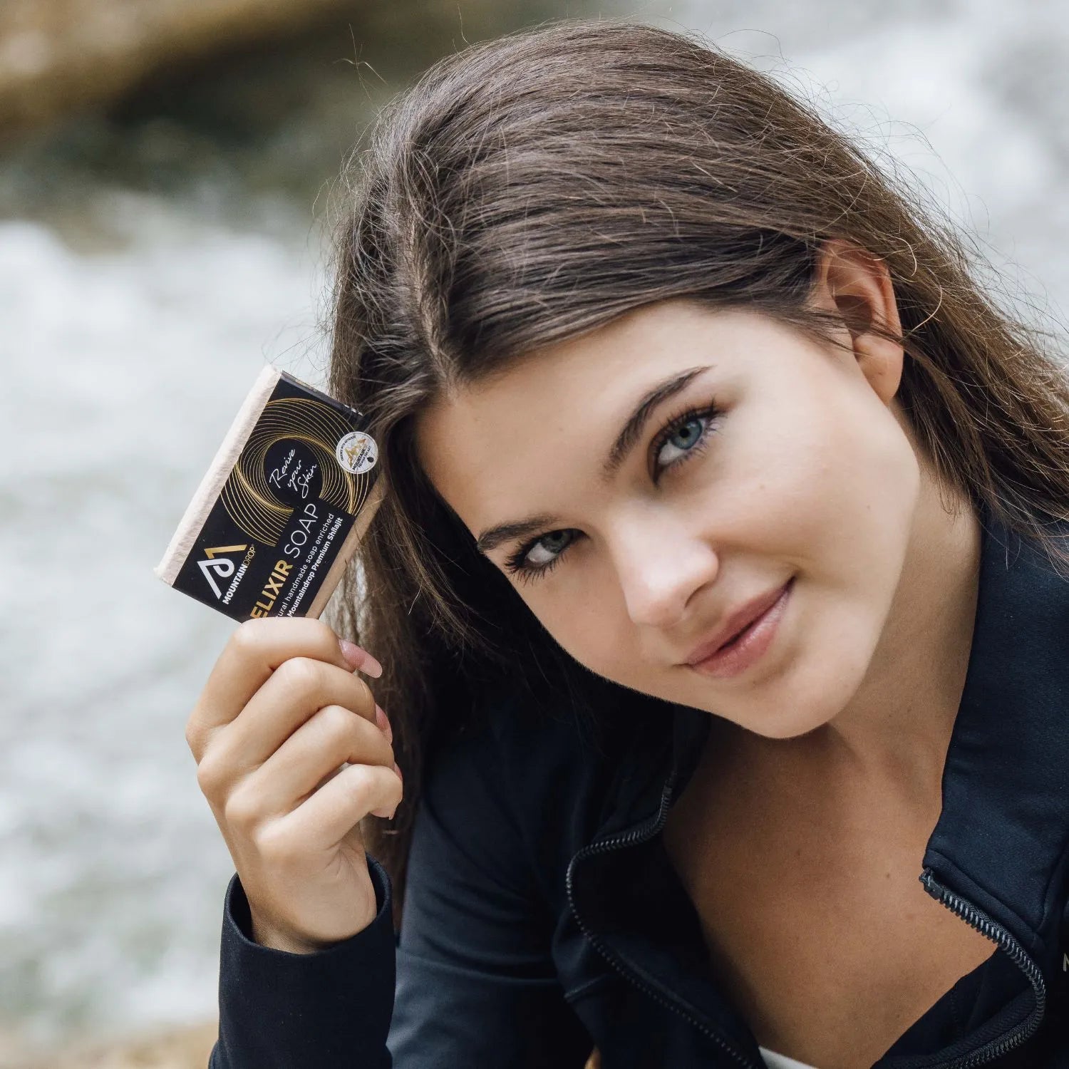 Nainen pitämässä Mountaindrop elixir saippuaa kädessä. Sopii miehille ja naisille ja pitää ihon hyvässä kunnossa.