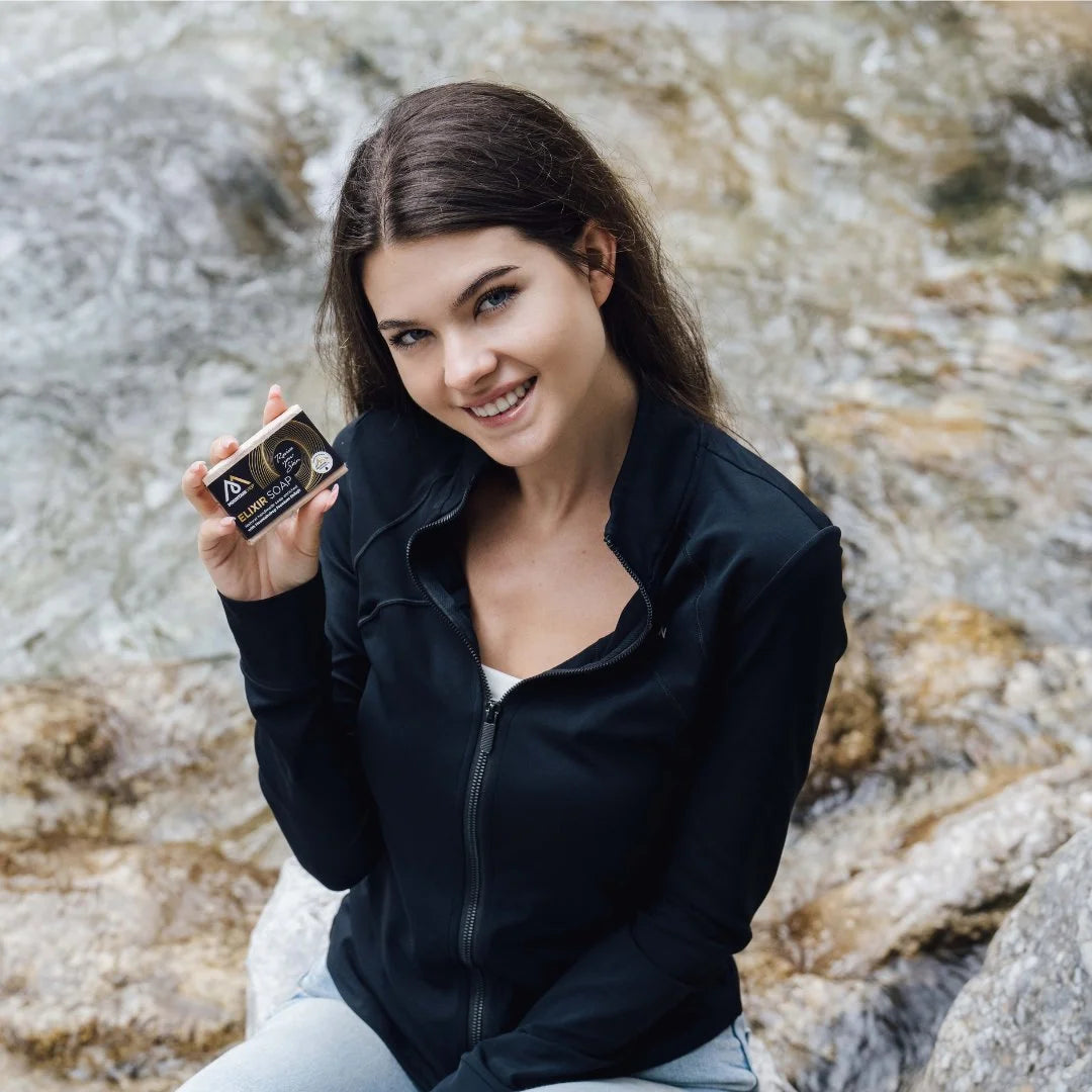 Nainen esittelee Mountaindrop Elixir Saippuaa – hellävarainen luonnonsaippua ihon puhdistukseen miehille ja naisille.