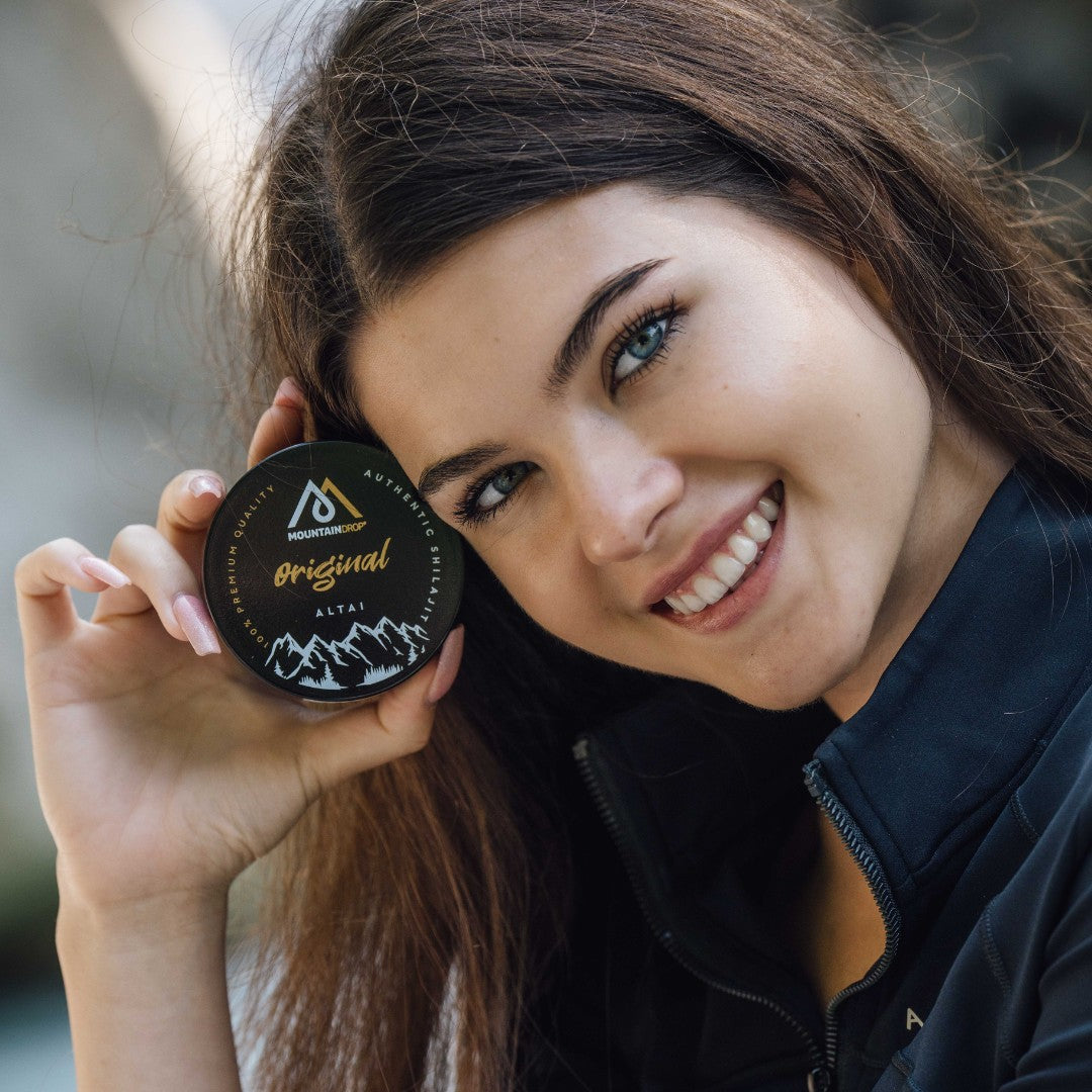 Nainen esitteleeMountaindrop Shilajit Altai -purkkia. Luonnollinen fulvohapon lähde energiatasoihin.